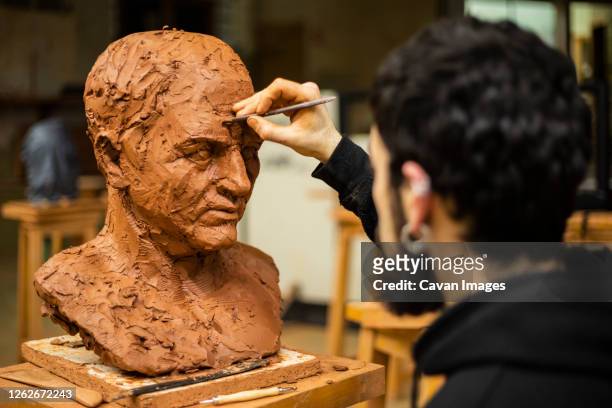 sculptor finishing a clay head - carving sculpture stock pictures, royalty-free photos & images