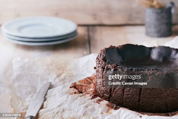 chocolate basque cheesecake on a wooden table ready to serve - chocolate souffle stock pictures, royalty-free photos & images