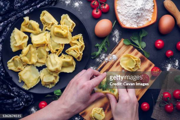 men's hands prepare italian pasta with ingredients. gastronomic concept - momo stock pictures, royalty-free photos & images