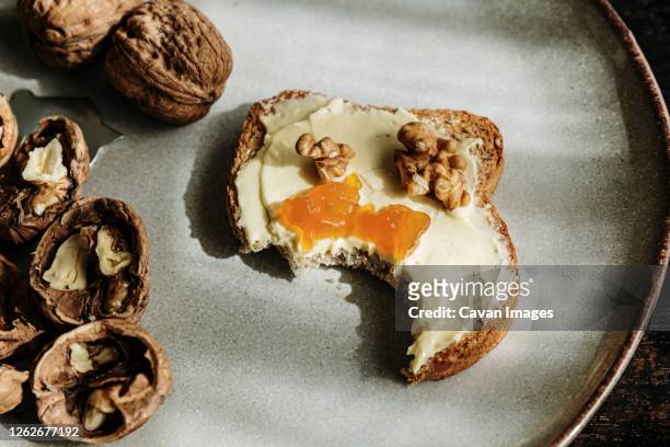 close up of delicious toast with butter, jam and walnuts on a plate - nut butter stock pictures, royalty-free photos & images