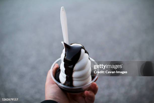 a hot fudge sundae in a plastic cup - filet de caramel photos et images de collection