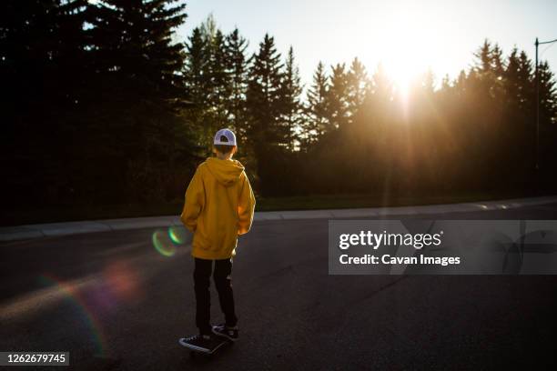 teen boy skateboarding on street - calgary skating stock pictures, royalty-free photos & images