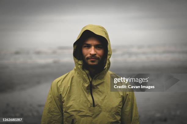 portrait shot of adventurous looking male during bad weather - bad weather stockfoto's en -beelden