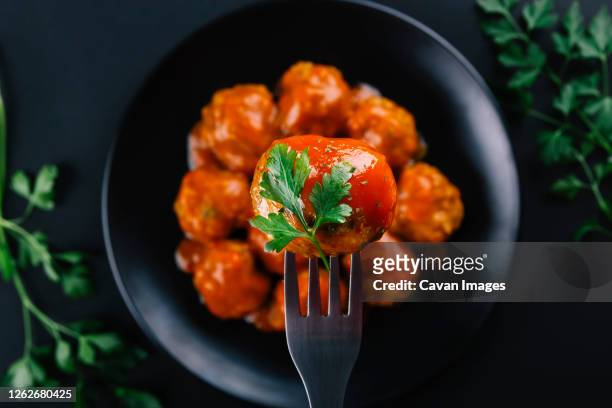 closeup of a homemade meatball seasoned with parsley and sauce - meatballs stock pictures, royalty-free photos & images