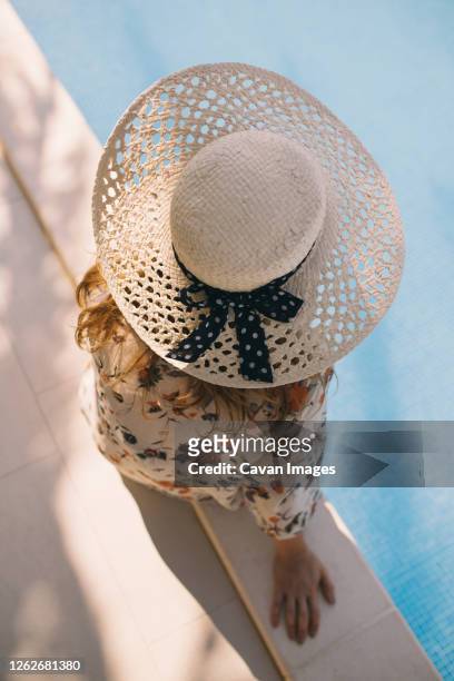 close up top view of woman with hat sitting by the pool - sombrero fedora foto e immagini stock