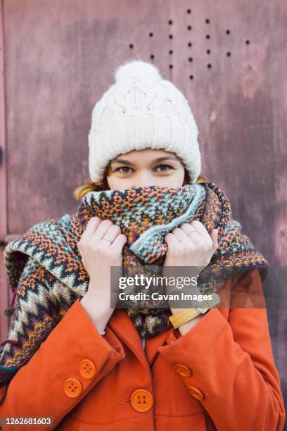 portrait of young woman with winter hat and scarf - orange coat stock pictures, royalty-free photos & images
