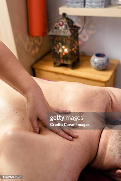 female masseuse massaging a male patient's scapula - escapula fotografías e imágenes de stock
