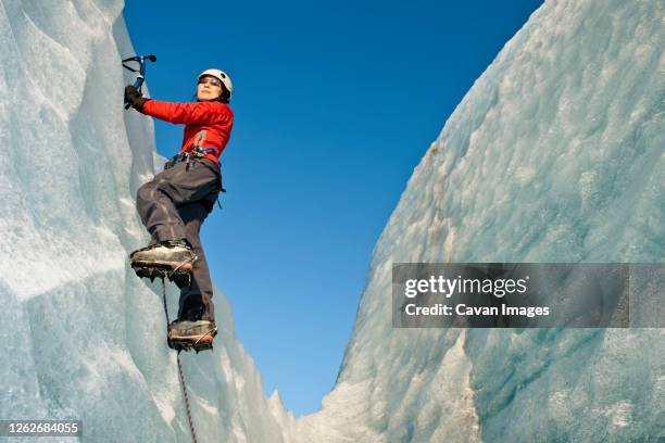 woman climbing on the fjallsjkull glacier in iceland - ice pick stock-fotos und bilder