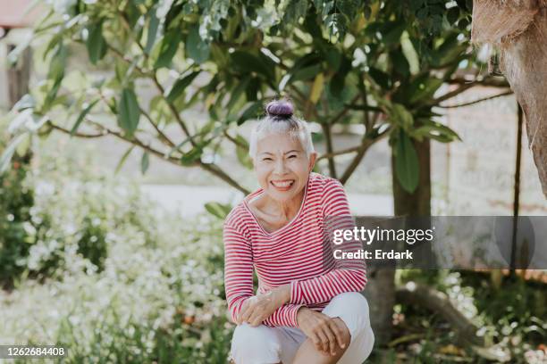 portrait of thai hipster senior woman in her garden - asian woman short hair stock pictures, royalty-free photos & images