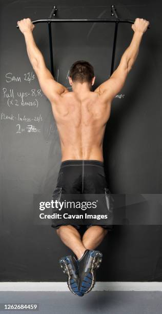 fit man with doing pull ups in gym - chin ups stock pictures, royalty-free photos & images