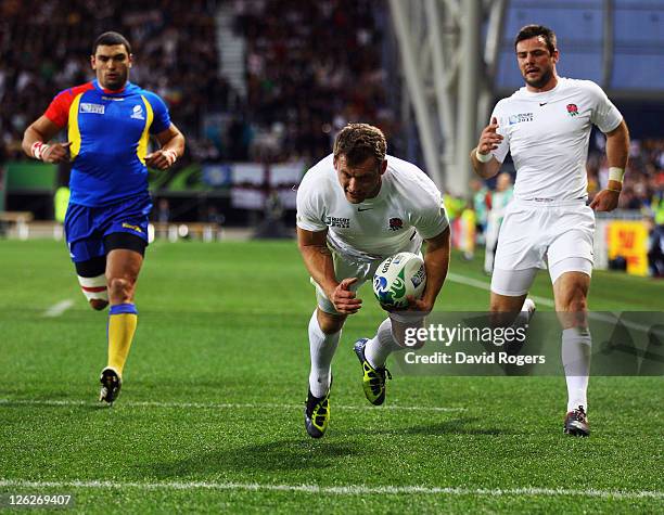 Mark Cueto of England scores his third try despite the challenge of Stefan Ciuntu of Romania during the IRB 2011 Rugby World Cup Pool B match between...