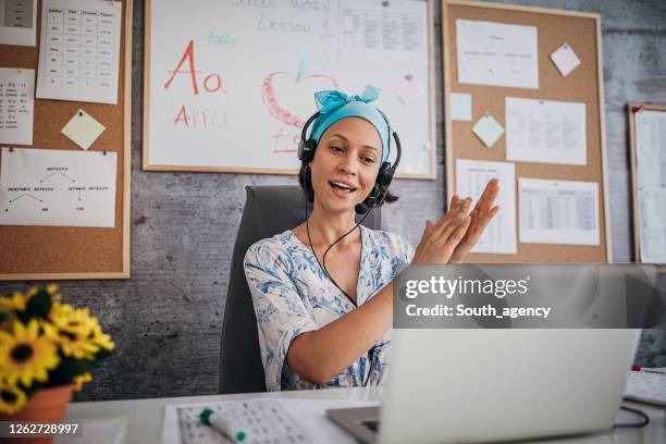 female professor holding online class and clapping hands to students for good answers - teacher zoom stock pictures, royalty-free photos & images
