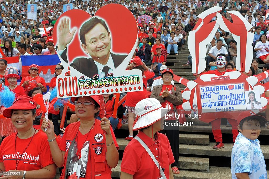 Thai red shirt supporters hold a portrai