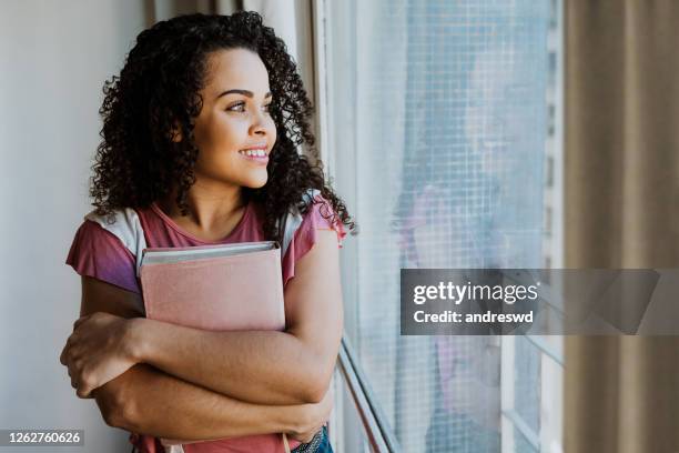 woman embraced with bible in window light - bible stock pictures, royalty-free photos & images