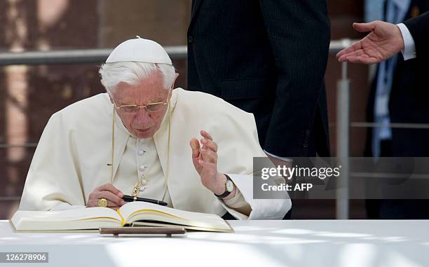 Pope Benedict XVI signs the guest book in Freiburg, south-western Germany, on September 24 on the third day of his first state visit to his native...