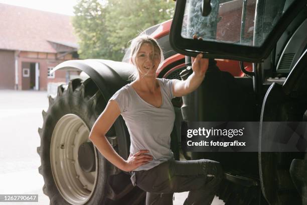 portrait of a female farmer in front of a tractor - lower saxony stock pictures, royalty-free photos & images