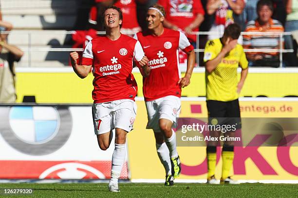 Nicolai Mueller of Mainz celebrates his team's first goal with team mate Marcel Risse as Lukasz Piszczek of Dortmund reacts during the Bundesliga...