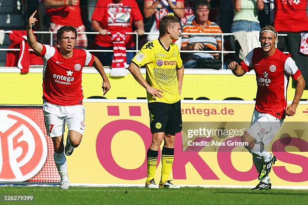 Nicolai Mueller of Mainz celebrates his team's first goal with team mate Marcel Risse as Lukasz Piszczek of Dortmund reacts during the Bundesliga...