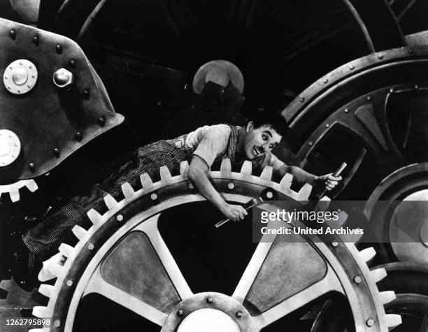Kino. Moderne Zeiten, USA Regie: Charles Chaplin, CHARLES CHAPLIN, Stichwort: Maschine, Zahnrad, Mechanik, Arbeiter, Werkzeug.