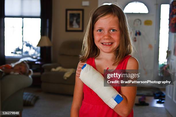 smiling girl with broken arm in cast - broken arm stock pictures, royalty-free photos & images