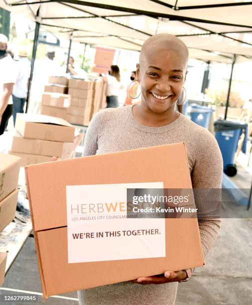 Actress Tiffany Haddish helps donate Chromebook computers to students in foster care during a drive-thru giveaway event at Wessons's district office...