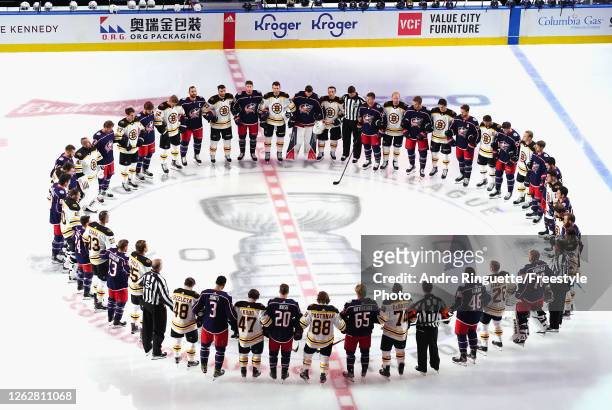 The Boston Bruins and the Columbus Blue Jackets gather at center ice prior to their exhibition game before the 2020 NHL Stanley Cup Playoffs at...