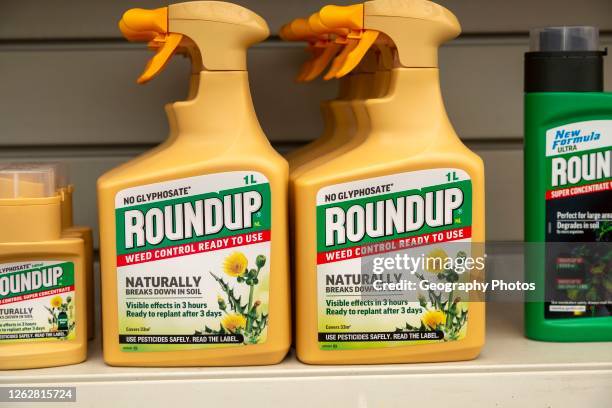 Plastic containers Roundup no Glyphospahte weed killer spray on shelf display in garden center, UK.