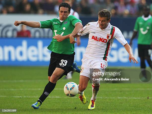 Daniel Baier of Augsburg fights for the ball with Manuel Schmiedebach of Hannover during the Bundesliga match between FC Augsburg and Hannover 96 at...