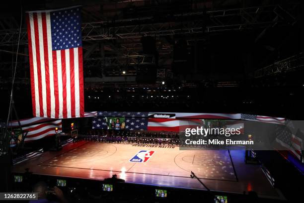 The America flag is seen as the Los Angeles Lakers and the LA Clippers wear Black Lives Matter shirt and kneel during the national anthem prior to...