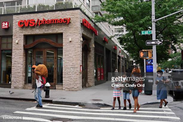 People cross the street in front of a CVS Pharmacy as the city continues Phase 4 of re-opening following restrictions imposed to slow the spread of...