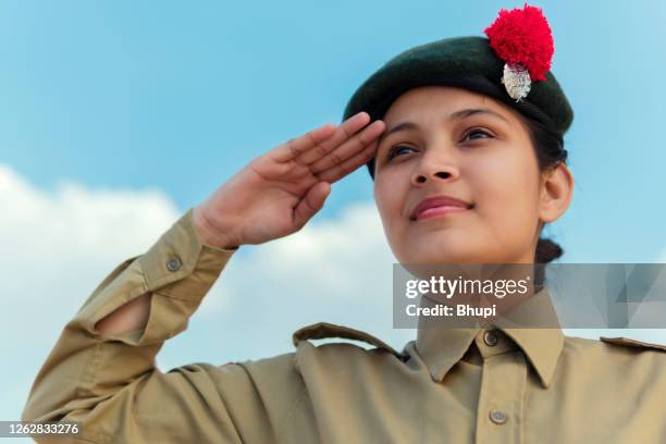 happy independence day - girl in ncc uniform and giving salute against blue cloudy sky. - republic day stock pictures, royalty-free photos & images