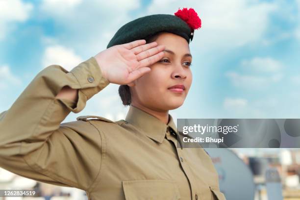 happy independence day - girl in ncc uniform and giving salute against blue cloudy sky. - exército indiano imagens e fotografias de stock