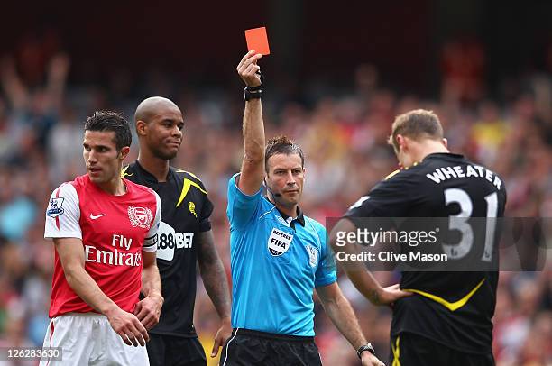 Referee Mark Clattenburg shows the red card to David Wheater of Bolton Wanderers during the Barclays Premier League match between Arsenal and Bolton...
