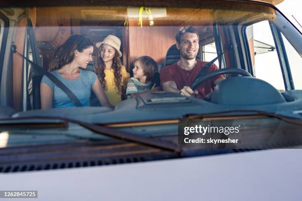 família feliz falando enquanto dirigia dentro de um trailer do acampamento. - family inside car - fotografias e filmes do acervo