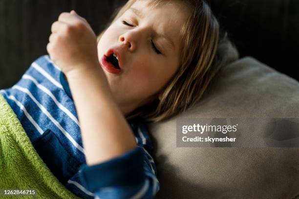 petit garçon toussant de l’œil fermé à la maison. - tousser photos et images de collection