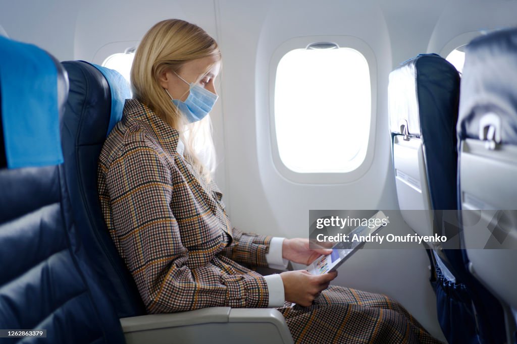 Woman wearing mask inside airplane