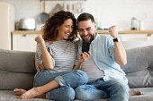 Overjoyed married couple celebrating online lottery win notification.