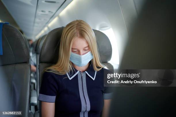 woman wearing mask inside airplane - frankfurt international airport stock-fotos und bilder