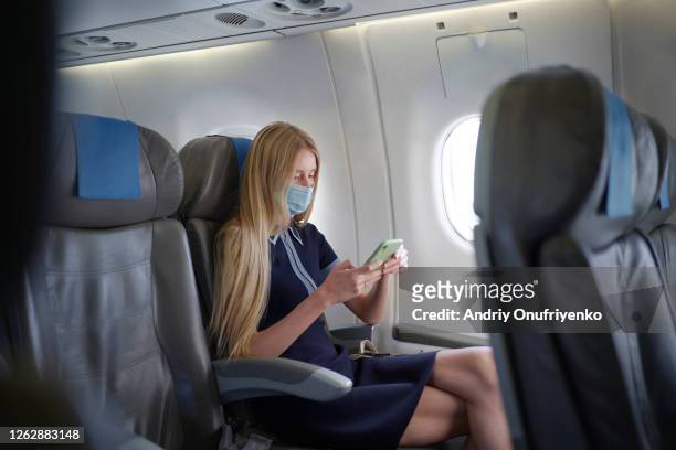 woman wearing mask inside airplane - frankfurt international airport stock-fotos und bilder