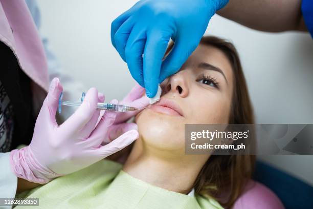 young woman having a hyaluronic acid injection in lips - ácido hialurónico imagens e fotografias de stock