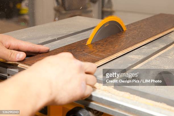 tradesman using a table saw to cut hardwood - engineered hardwood imagens e fotografias de stock
