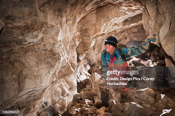 female athlete exploring a cave - 洞窟 個照片及圖片檔