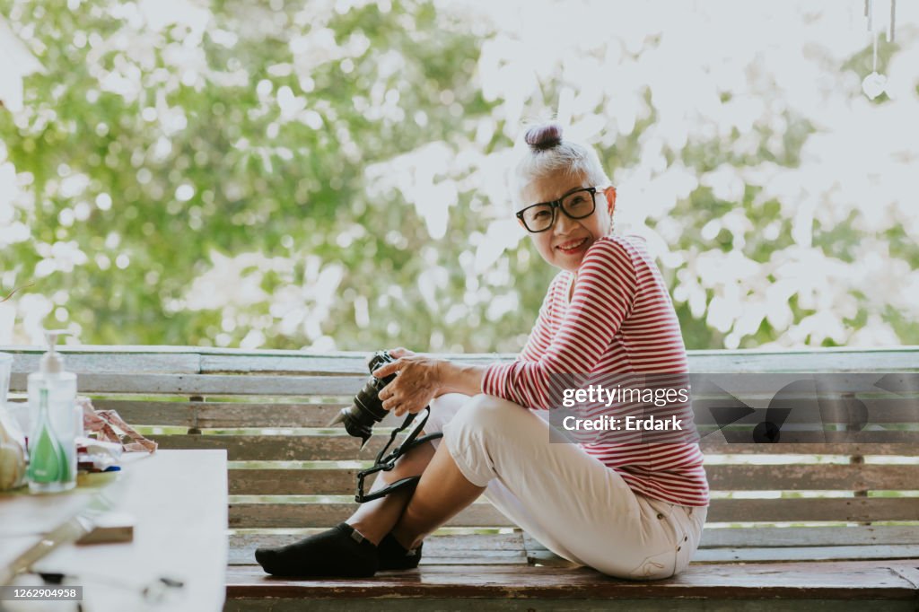 Thai senior hipster woman with her love hobby while quarantine at home
