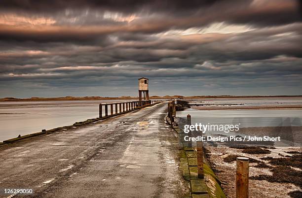 the causeway from holy island - northumberland stock pictures, royalty-free photos & images