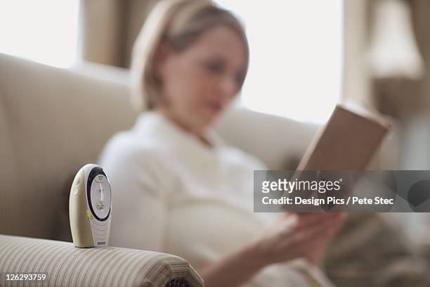 mother reading by baby monitor - baby monitor stock pictures, royalty-free photos & images