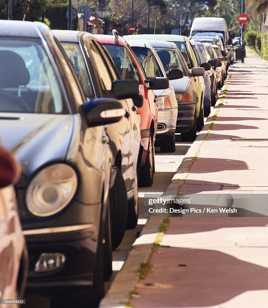 Cars parked in line on street