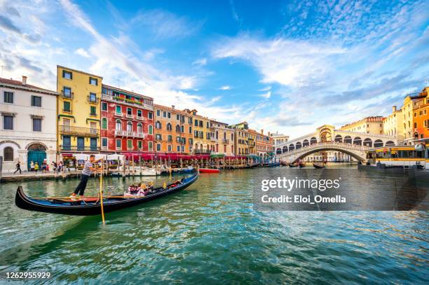 gondel auf canal grande mit rialtobrücke bei sonnenuntergang, venedig - gondel stock-fotos und bilder