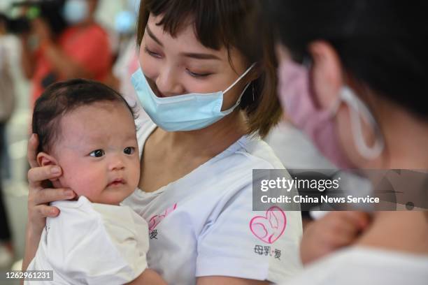 Twenty mothers breastfeed their children during a flash mob event to raise public awareness of breastfeeding at a subway station on July 31, 2020 in...