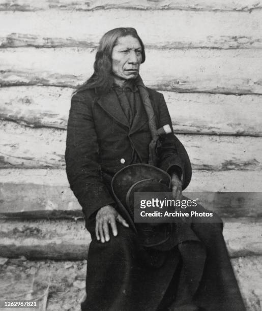 Native American chief Red Cloud , of the Oglala Lakota Sioux, wearing a black overcoat, his hat resting in his lap, USA, circa 1875. Red Cloud was...
