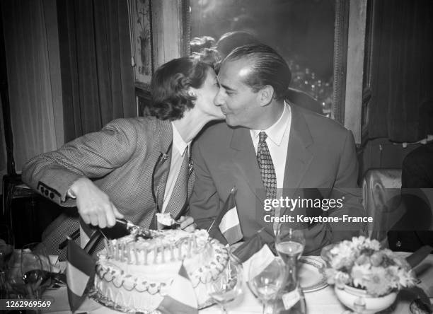Le réalisateur italien Roberto Rossellini célébrant son anniversaire dans un restaurant avec son épouse, l'actrice Ingrid Bergman, à Paris, le 8 mai...